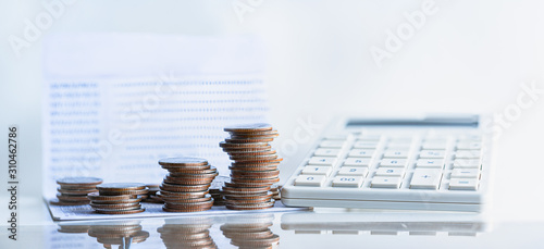 Bank passbook with calculator and stack money coin for growing business.Passive income, Pension and retirement concept. Investment in business development to success, dividend payment to investors.