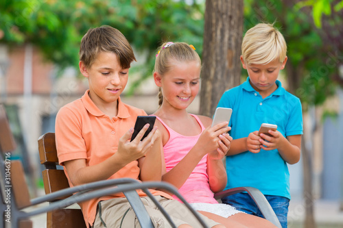 children are chatting in phones in the playground. photo