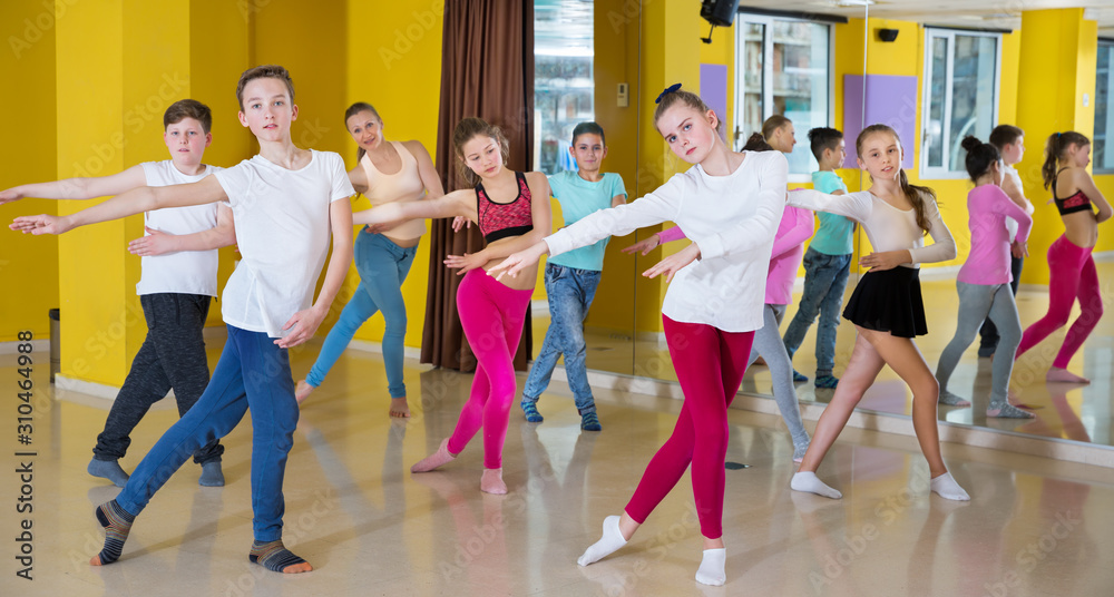 Children participating in dance class, following their teacher