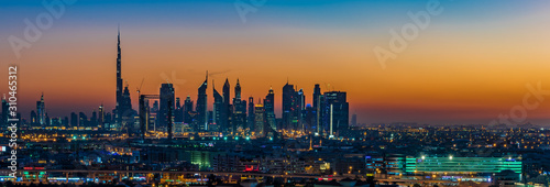 Dubai susnet over the creek in the background the silhouette of the tall buildings © Joerg