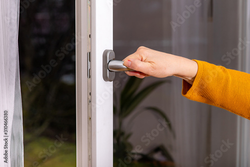 Woman opens the window to ventilate