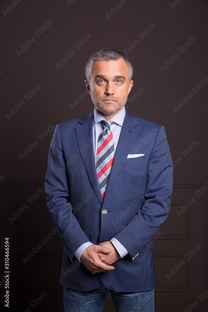 A portrait of a man on a matte brown wall in the background. A businessman. A portrait of a man on a matte brown wall in the background. A businessman.