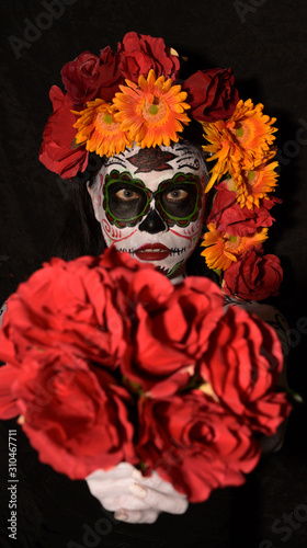 Halloween, Day of the Dead body paint on woman giving flower to you on black background