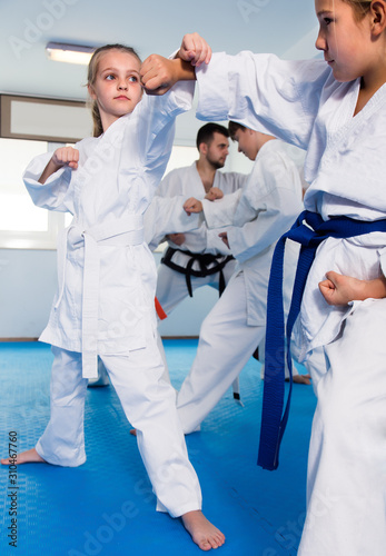 Young children sparring in pairs in karate class