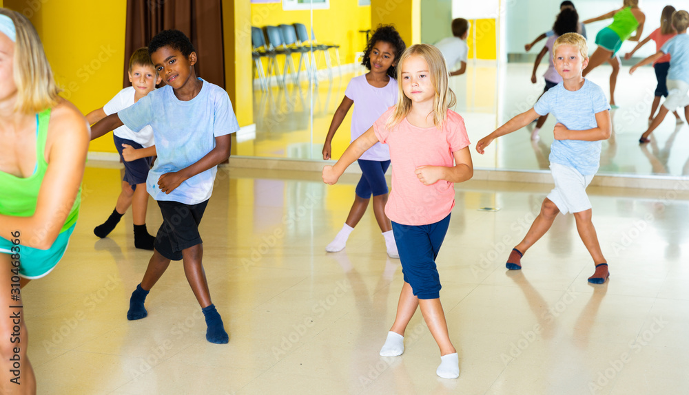 Emotional children performing modern dance in fitness studio