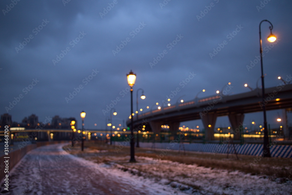 promenade with lanterns on a dark winter evening