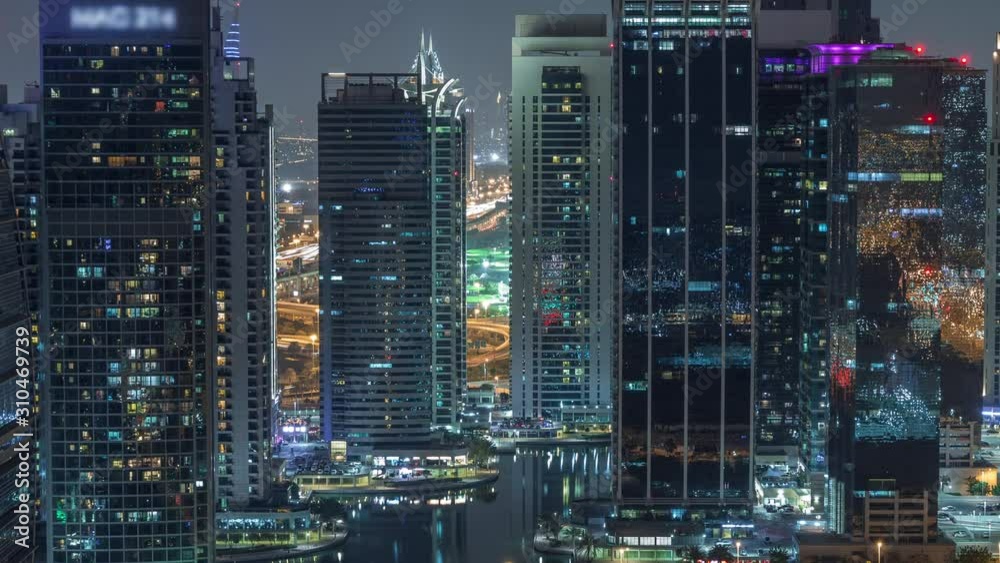 Jumeirah Lake Towers residential district aerial night timelapse near Dubai Marina. Illuminated modern skyscrapers and traffic from above Jumeirah Lake Towers residential district aerial night timelapse near Dubai Marina. Illuminated modern skyscrapers and traffic from above