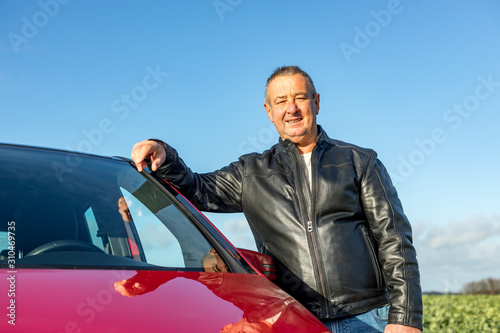 Man is standing next to his car