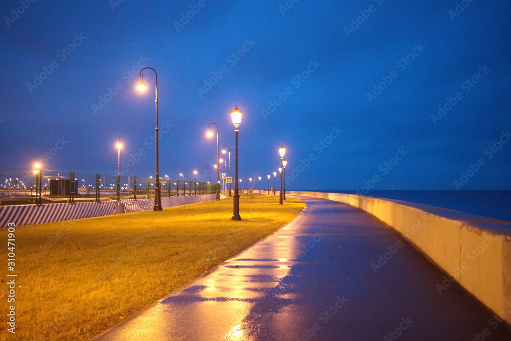 promenade with lanterns on a dark winter evening