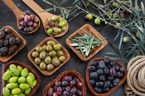 Mixed types of olive in the bowls and olive oil on the table