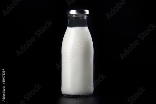 Bottles of milk isolated on a black background. Dairy food.