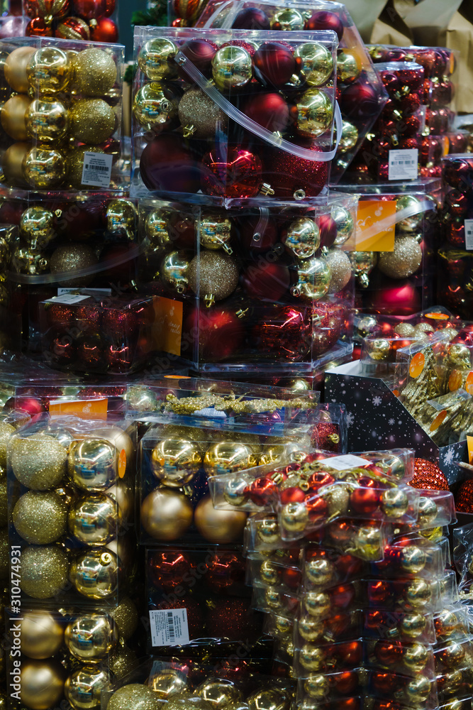 Multi-colored Christmas balls in transparent boxes in the store.