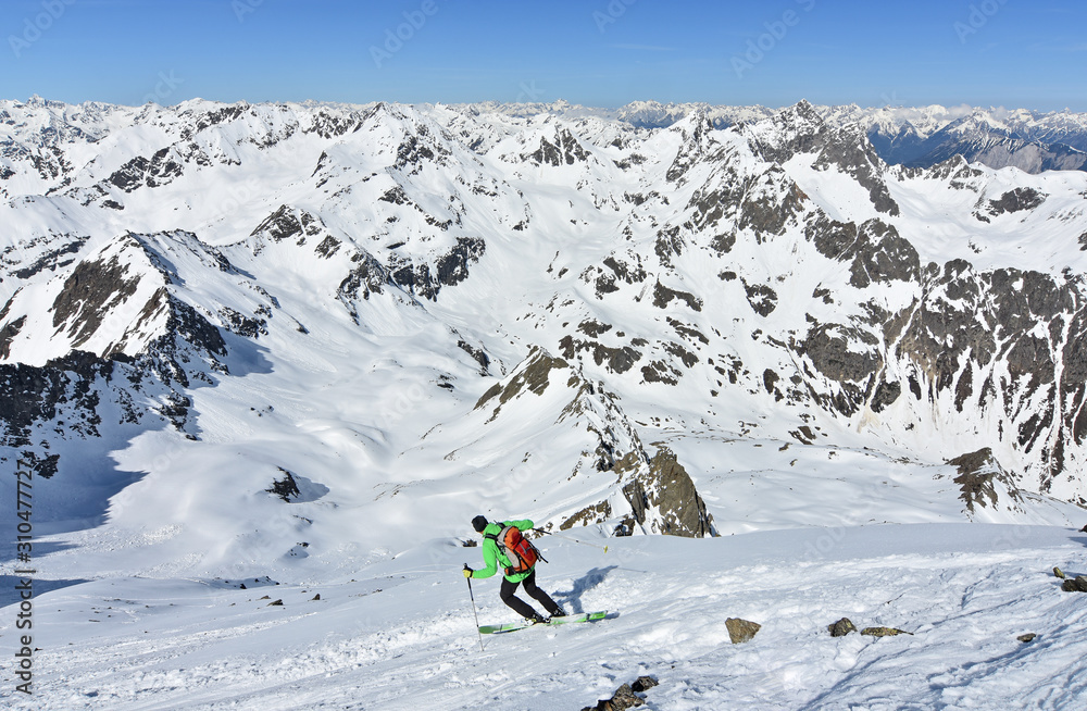 Ski mountaineer skiing at Sulzkogel in wild alpine landscape. Stubai Alps, Tirol, Austria