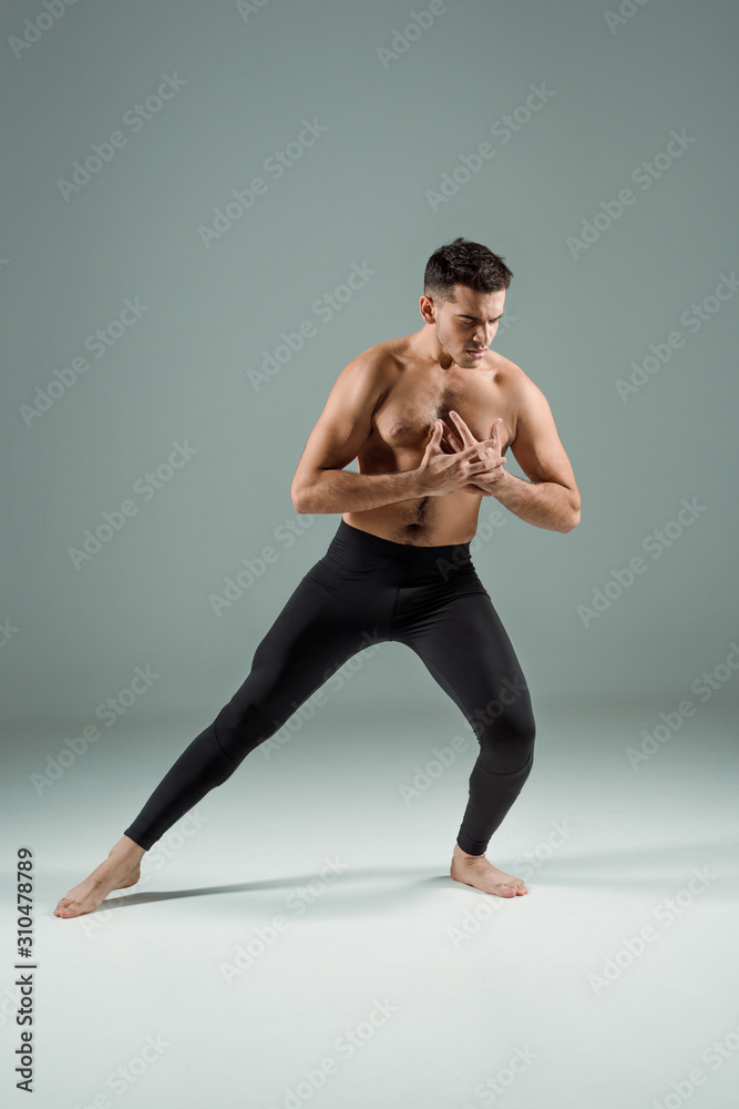 handsome dancer in black leggings dancing contemporary on dark background