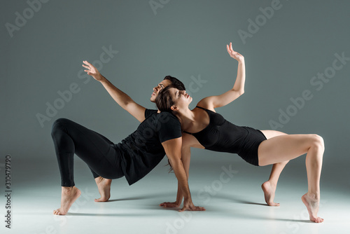handsome and attractive dancers dancing contemporary on dark background