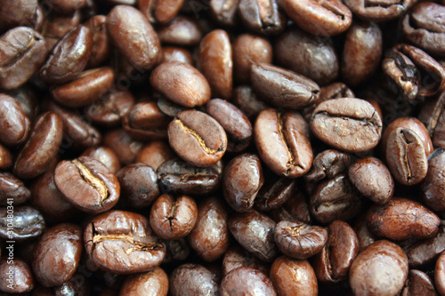 Close up and macro shot of roasted coffee beans top view background.