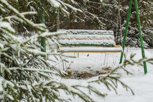 swing in the winter forest covered with snow