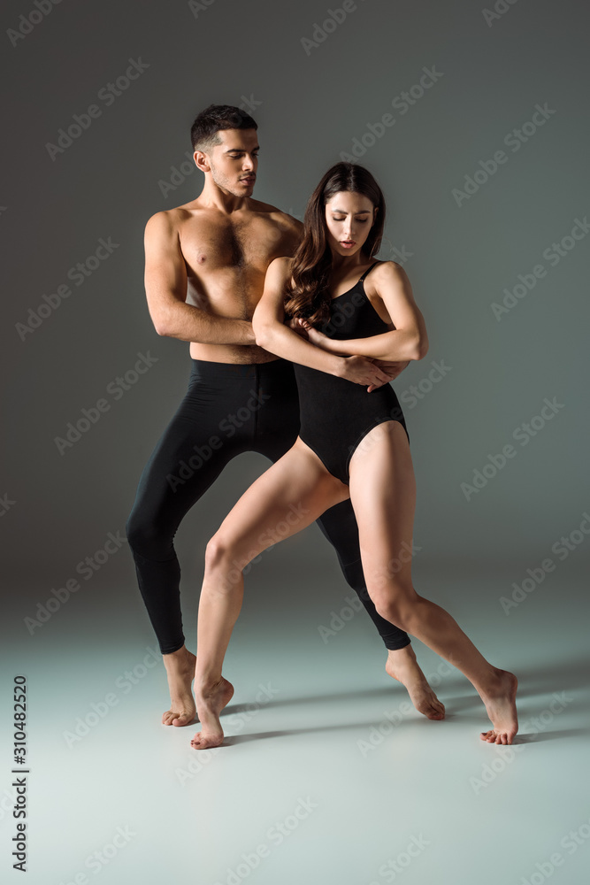 attractive and handsome dancers dancing contemporary on dark background