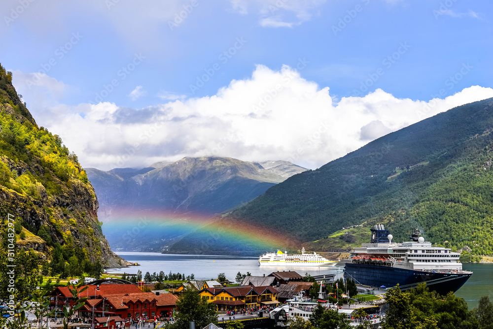 cruise ship under a rainbow in the fjords of norway