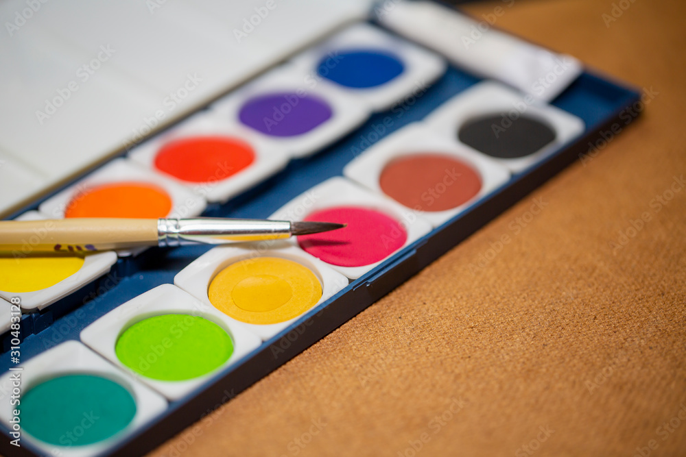 Painting tools including brushes, watercolor on nice gentle dark gray and textured background. Painting tools including brushes, watercolor on nice gentle dark gray and textured background.