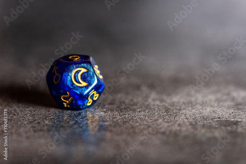 Blue Astrology Dice with symbol of the Moon on grey background photo