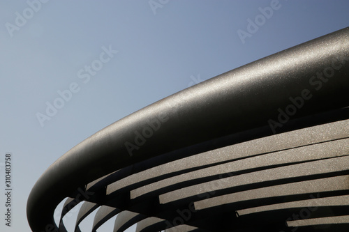 Metal girders. Curved detail of industrial building. Steel lath structure. Abstract modern architecture. Anti-corrosion protective powder coating. Geometric background with parallel lines and curves.