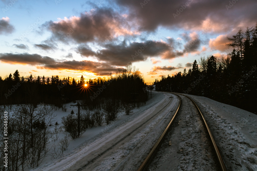 Vibrant sunset over winter train tracks