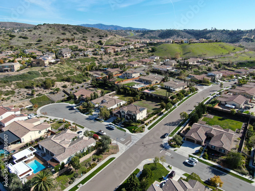Aerial view of neighborhood with residential modern subdivision luxury houses and small road during sunny day in Chula Vista, California, USA.