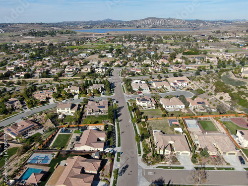 Fototapeta Naklejka Na Ścianę i Meble -  Aerial view of neighborhood with residential modern subdivision luxury houses and small road during sunny day in Chula Vista, California, USA.