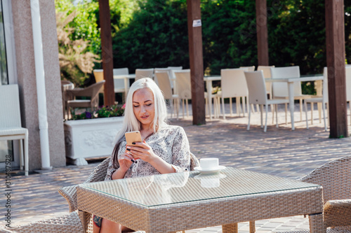 blonde girl sitting at the beach restaurant coffee photo