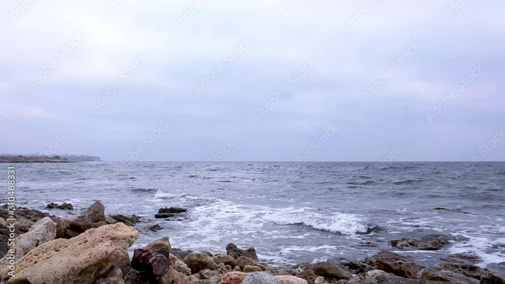 Waves wash over rocky shore in cloudy weather. Waves wash over rocky shore in cloudy weather.