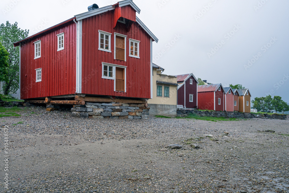 Naklejka premium Old wooden building on the beach in the city of Mosjoen in Northern Norway during rainy weather. Architecture, landscape near me and travelocity concept.