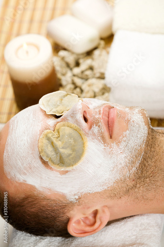 man with the face mask and tea bags on his eyes