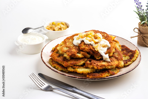 Exposition of home made potato pancakes on white table, traditional tasty food. 
