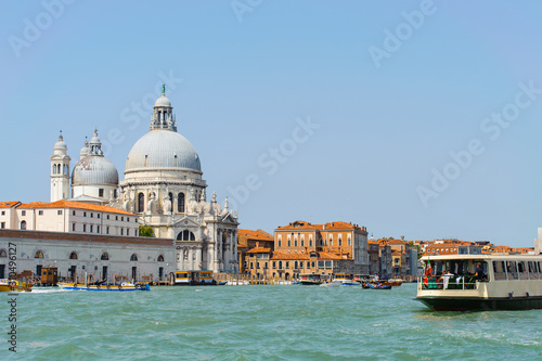 Bright sunny panorama view of The Grand Canal with gondola and Santa Maria della Salute church, Venice, Italy. Beautiful photo background of the venetian canal.