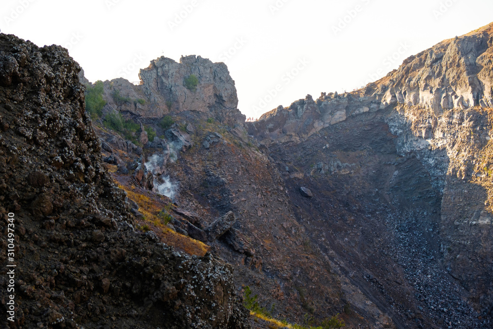 Vesuvius volcano crater with smoke next to Naples. Campania region, Italy. Popular Italian travel destination. Hiking trail on Vesuvius volcano. Vesuvius volcano crater with smoke next to Naples. Campania region, Italy. Popular Italian travel destination. Hiking trail on Vesuvius volcano.