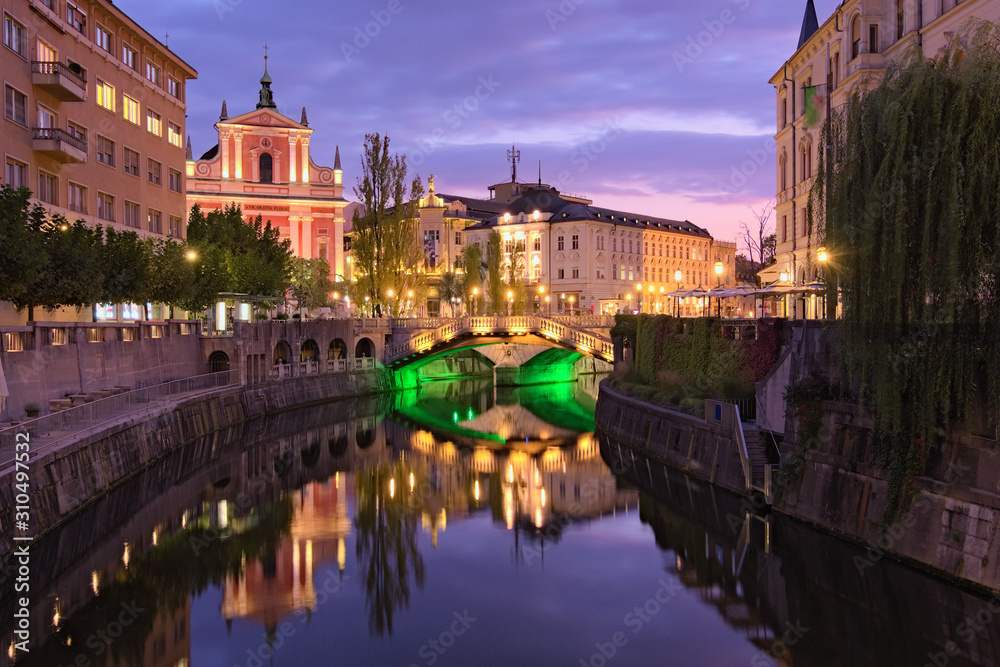 Fototapeta premium Malowniczy nocny krajobraz starego miasta. Rzeka Ljubljanica ze słynnym Potrójnym Mostem i średniowiecznymi kolorowymi budynkami. Romantyczna i spokojna scena. Ljubljana, Słowenia