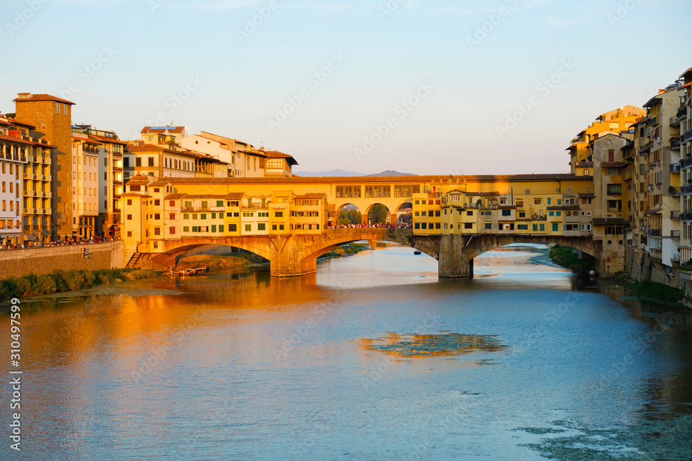 Beautiful landscape view of amazing Florence city with famous medieval stone bridge Ponte Vecchio and the Arno River at sunset light. Firenze scenery panorama, Italy Europe. Italian summer vacation.