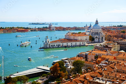 Beautiful Grand Canal with Basilica and gondolas in Venice, Italy. Romantic city on water. Aerial top view from tower of San Marco Cathedral. Cityscape panorama of Italian houses with red roofs.