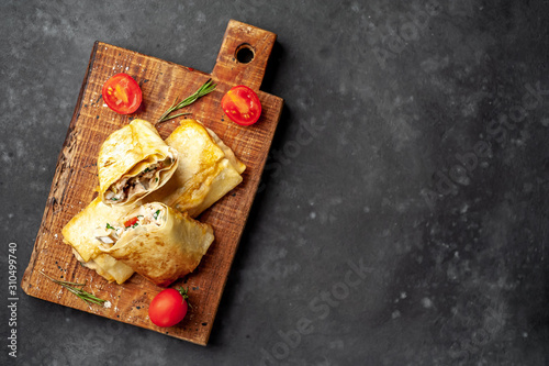 Mexican burrito wraps with chicken and vegetables on a cutting board, on a background of concrete, mexican shawarma