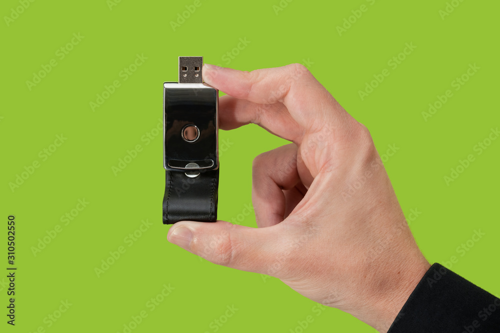 Dark pen drive on hand with isolated green background