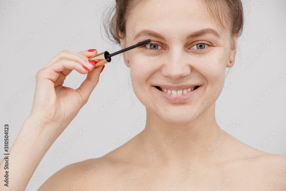 Beautiful brunette woman paints the eyelashes. Beautiful woman face. Makeup detail. Beauty girl with perfect skin Beautiful brunette woman paints the eyelashes. Beautiful woman face. Makeup detail. Beauty girl with perfect skin