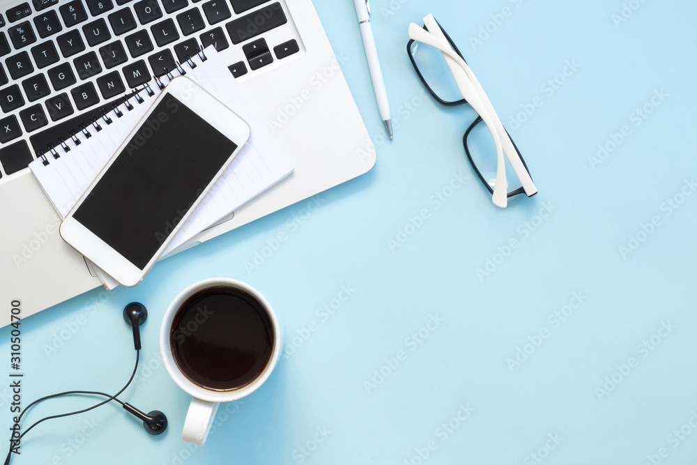Blue office desk table with notebook, pen, glasses, cup of fresh espresso coffee. Top view with copy space, flat lay Blue office desk table with notebook, pen, glasses, cup of fresh espresso coffee. Top view with copy space, flat lay