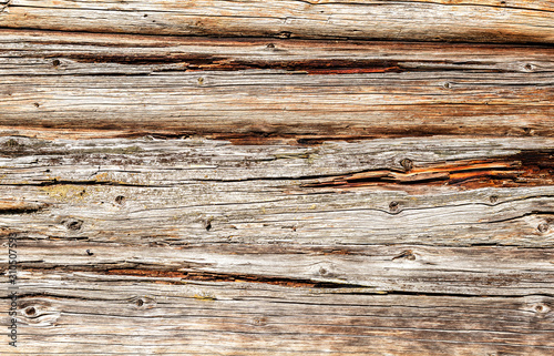 Old rough wooden logs with cracks as background