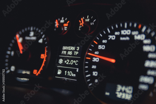 Close up shot of a speedometer in a car. Car dashboard. Dashboard details with indication lamps.Car instrument panel. Dashboard with speedometer, tachometer, odometer. Car detailing.
