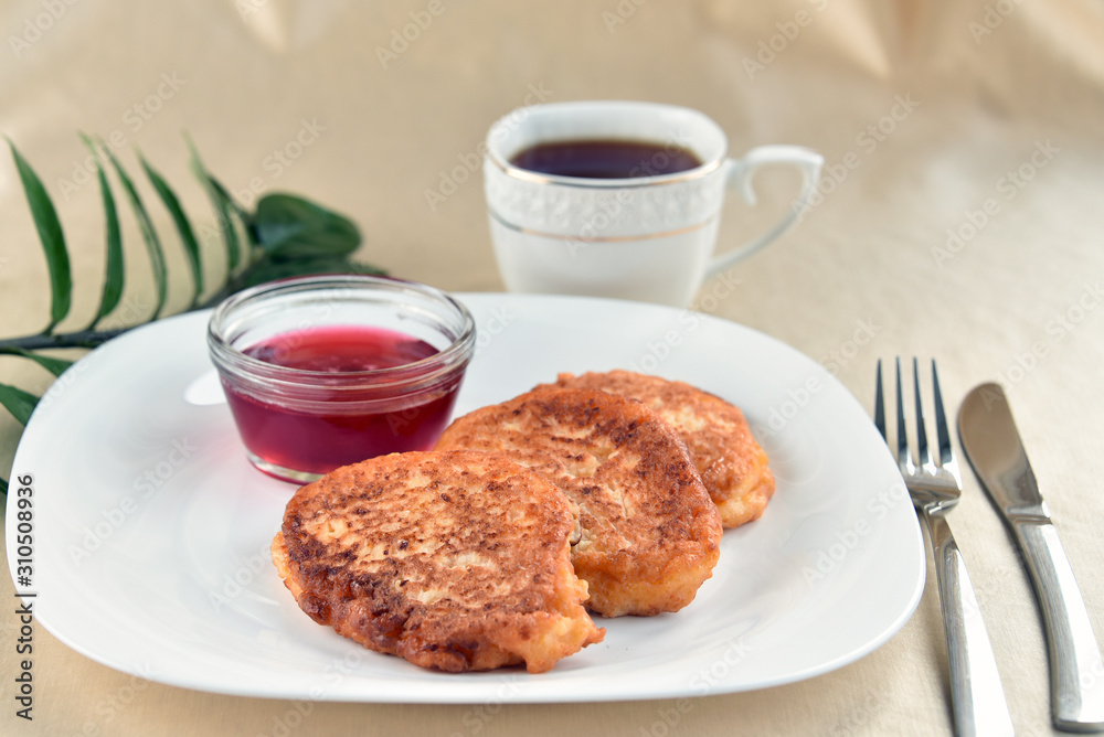 Fritters on a white plate with cherry sauce