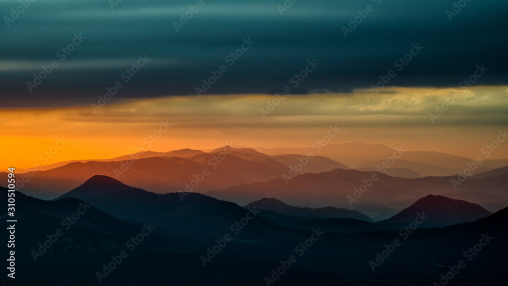 Splendid mountain sunrise. Mountains silhouettes on a beauty background. Bieszczady Mountains Poland.