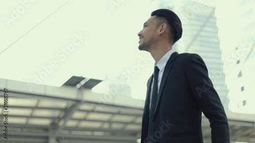 Wallpaper Mural Successful businessman. Asian man winner celebrates the good news feeling happy enjoyment while standing on the street near a big office building urban. Torontodigital.ca