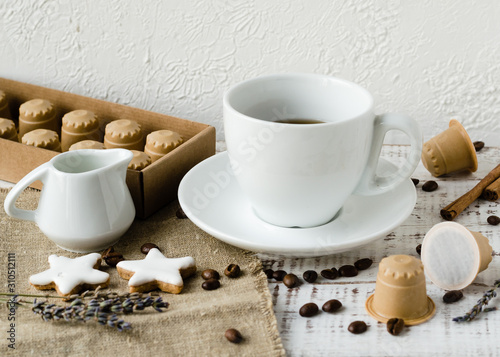 Te cup of coffee with wooden coffee capsules, lavander and coffee beans on white wooden background. Coffee capsule made of wood. Zero waste and no plastic concept. Eco coffee capsules