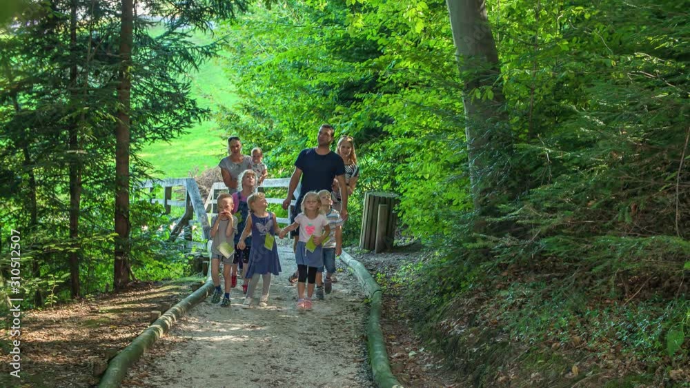 Large family walking in the forest along a path, laughing and enjoying themselves, happiness, young children, mom and dad Large family walking in the forest along a path, laughing and enjoying themselves, happiness, young children, mom and dad
